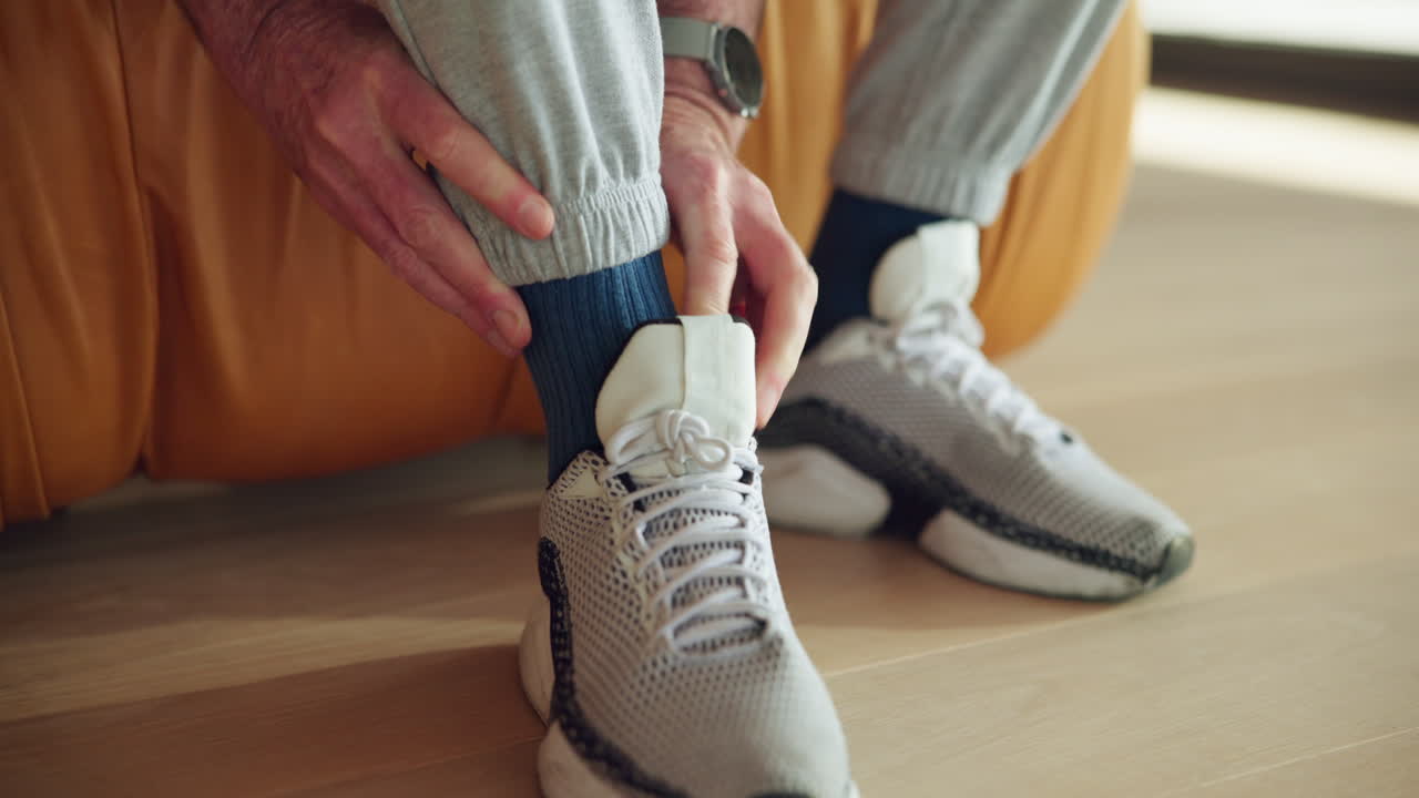 Primo piano di una persona che modifica una scarpa sportiva e un calzino