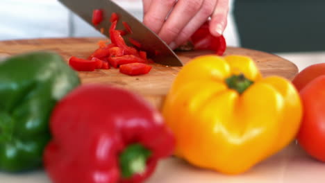 woman chopping a red pepper