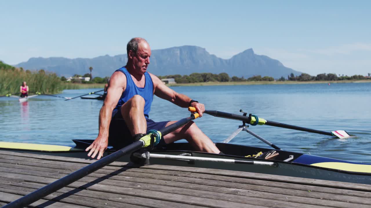 hombre caucásico mayor preparando un bote de remo en un río