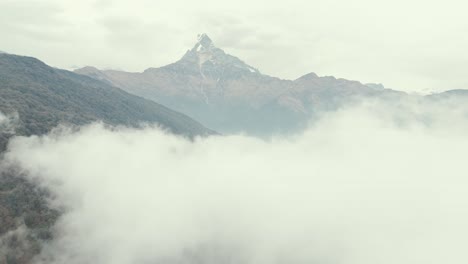 spectacular aerial ascending through cloud revealing machapuchare mountain