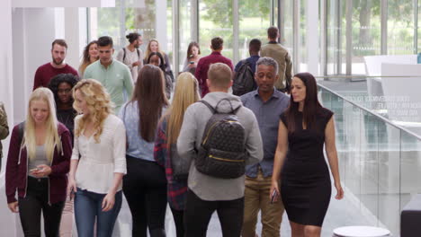 students and teachers walk in foyer of a modern university, shot on r3d