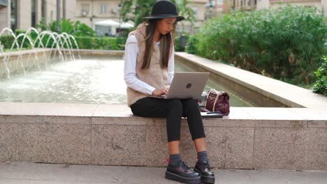 hispanic woman browsing laptop on street