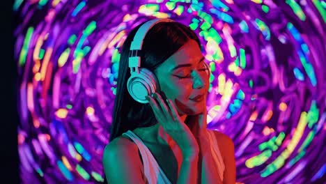 woman listening to music with headphones in neon lights