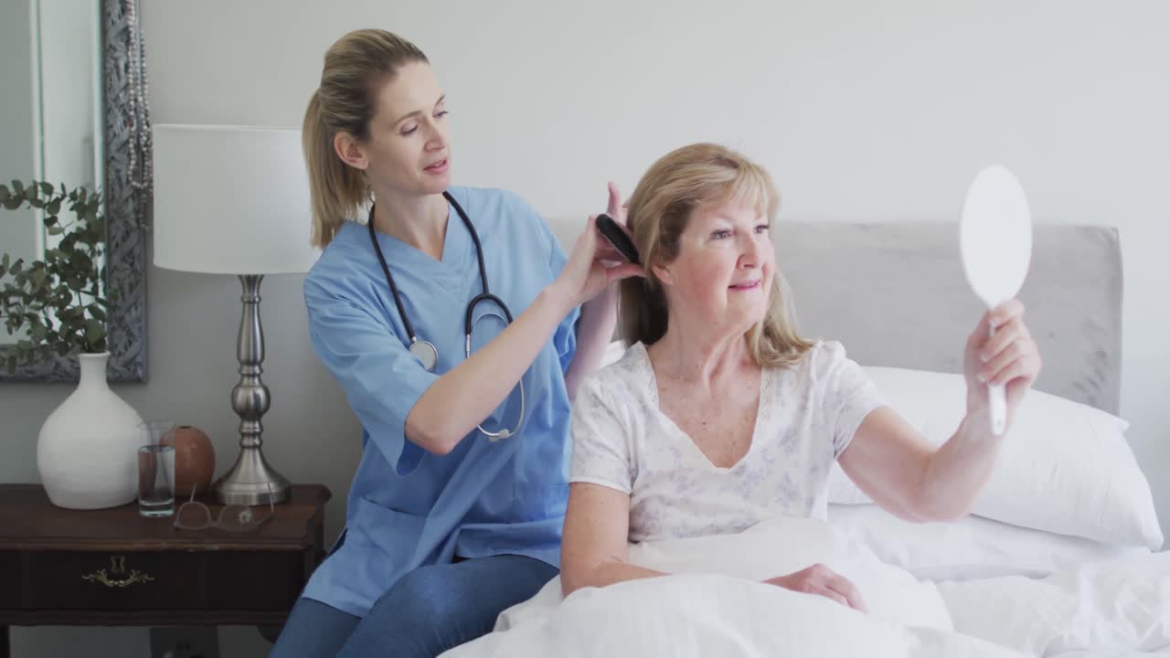 Female health worker brushing hair of senior woman at home