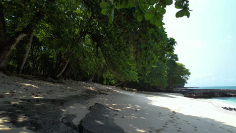 aerial view low over white sand on a beach, sunny day in sao tome, africa