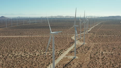 Die-Kamera-Schwenkt-Hoch-Und-Kippt-Entlang-Der-Fluchtlinie-Von-Windmühlen-Auf-Einem-Solarpark-Nach-Unten