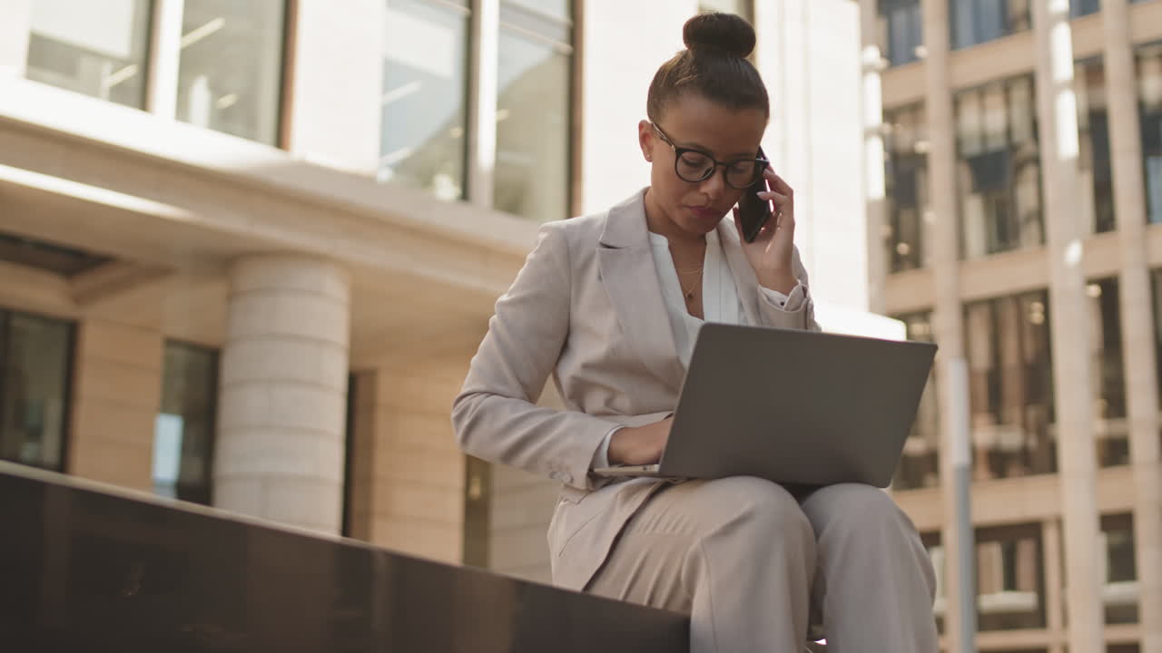 Donna d'affari seria che parla al telefono all'aperto
