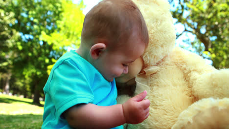 un niño lindo jugando con un oso de peluche