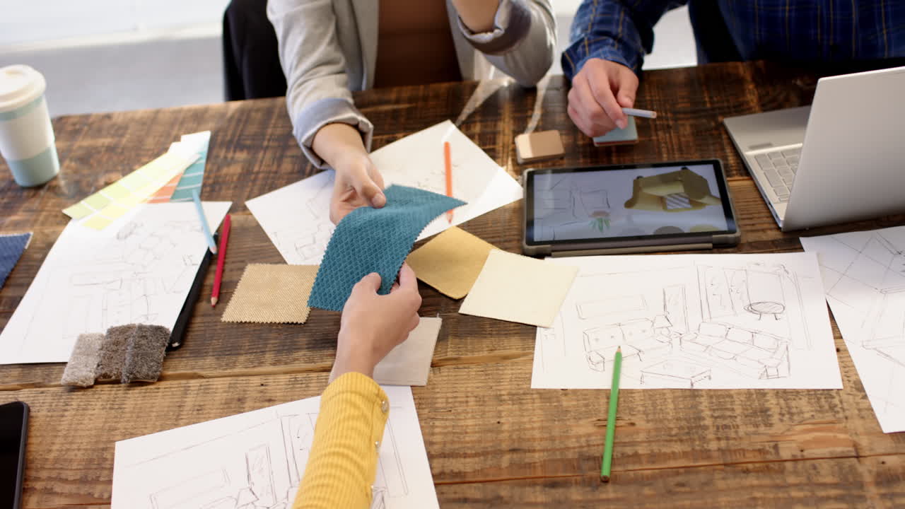 Interior design, multiracial team reviewing fabric samples and digital sketches, at office