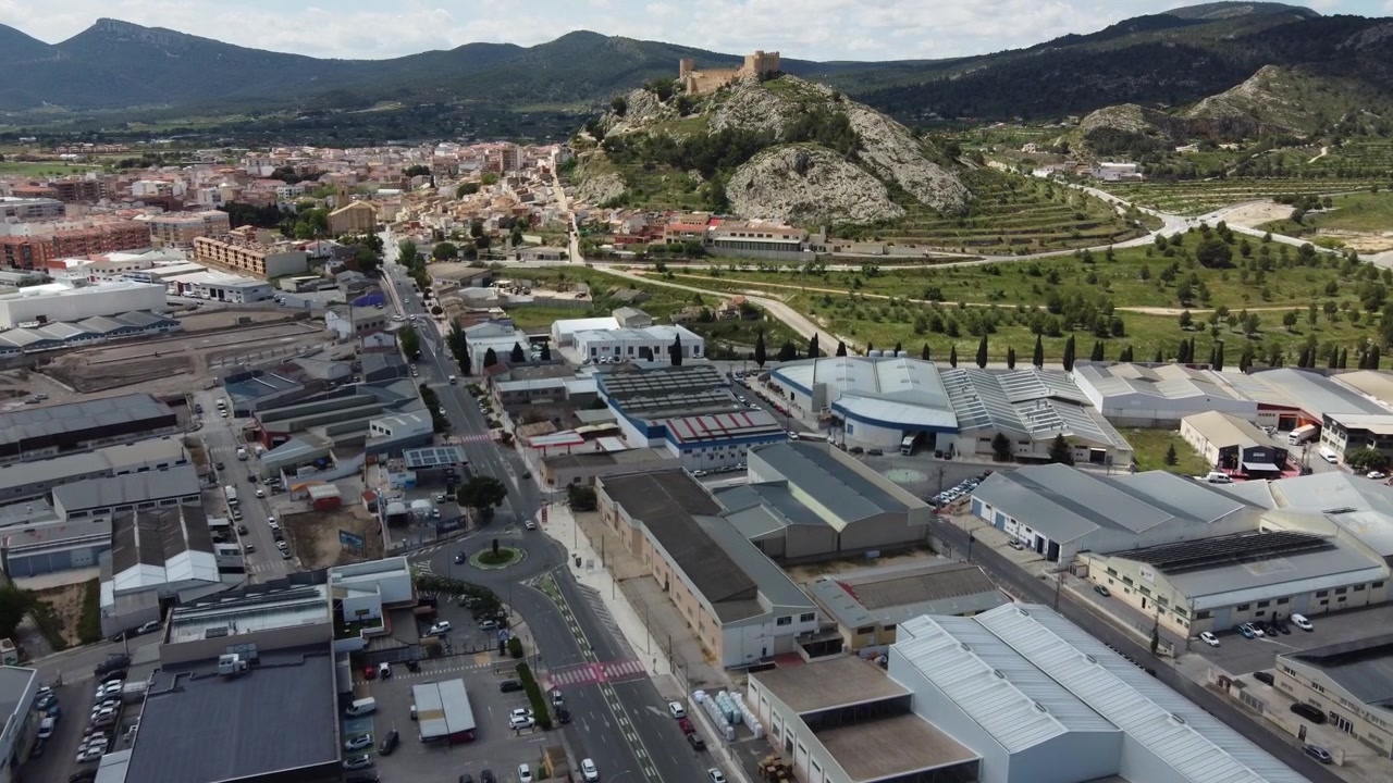 Zona industriale con la città e il castello di Castalla sullo sfondo, Spagna.