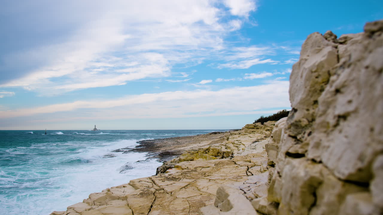 olas marinas que crean crestas y se rompen en la costa rocosa creando espuma y niebla, foco de atracción