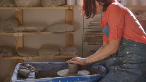 young female potter working in her studio