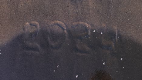 2021 written in wet sand