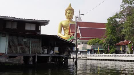 a shot of the impressive buddha statue wat paknam in the backwaters of bangkok, in the poor part of the city in the capital of thailand in asia