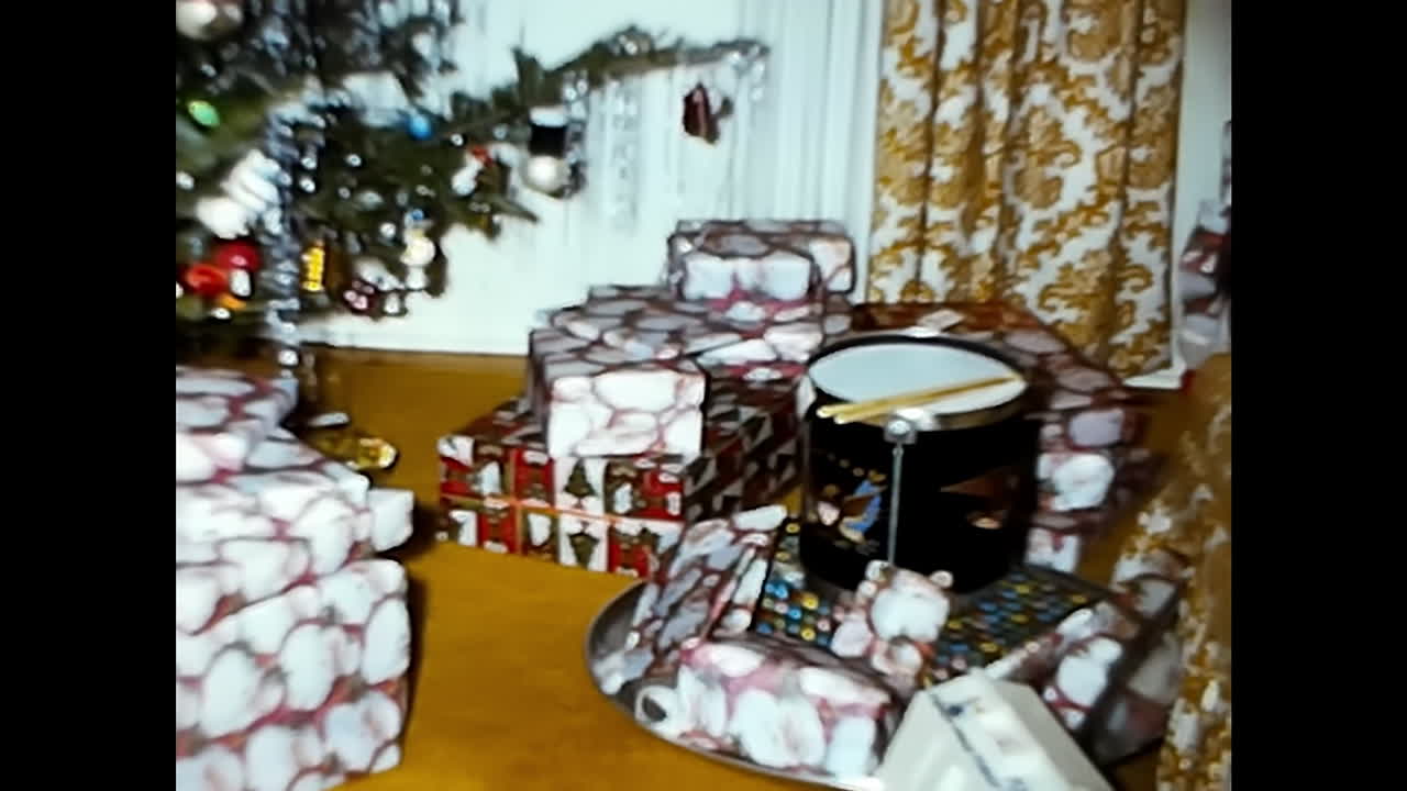 Group of Wrapped Presents Under Christmas Tree. CIRCA USA - 1970s: A festive scene showing a group of wrapped presents neatly arranged beneath a decorated Christmas tree.