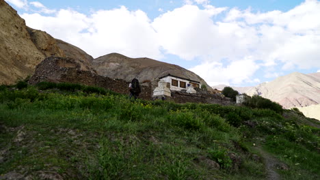 backpacker in front of the ancient village hankar, on the markha valley trek in the himalayas in india