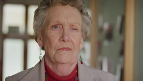 portrait-of-old-caucasian-woman-standing-by-window-looking-pensive-contemplative-in-retirement-home-background-slow-motion