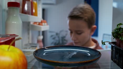 niño mirando en un refrigerador para la comida