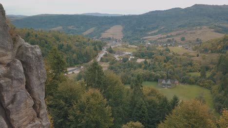 Newlyweds-stand-on-a-high-slope-of-the-mountain.-Groom-and-bride.-Aerial-view