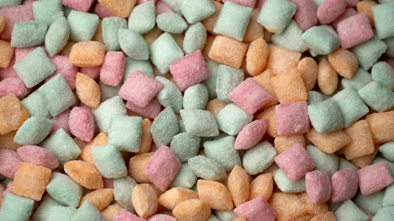 almohadillas de caramelo dulces mezcladas con azúcar de bocadillo girar el fondo