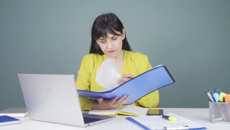 Woman-working-on-laptop-throws-files-angrily.