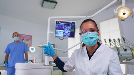 doctor measuring woman temperature before dental examination
