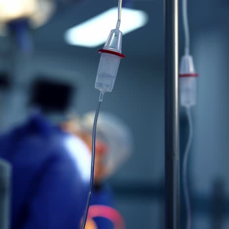 dropper with drug slowly dripping downtube. iv tube in action. dripper on the blur background of a surgical process