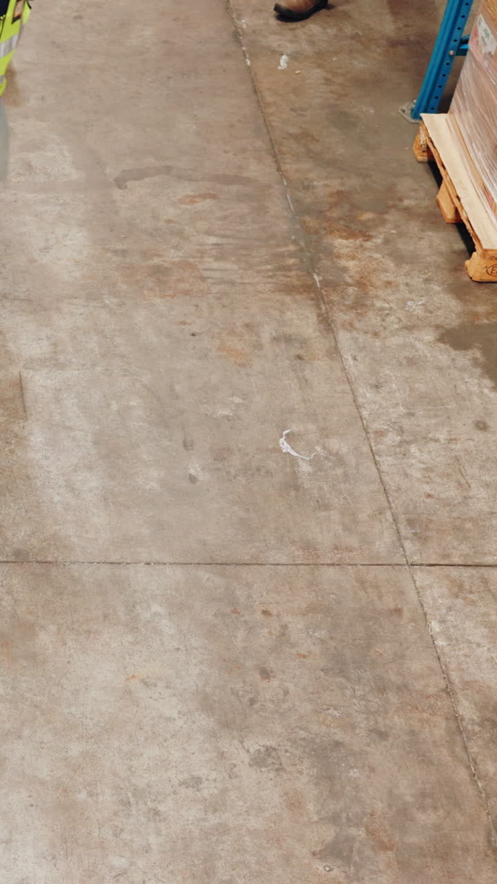 Warehouse worker pulling a pallet jack with boxes