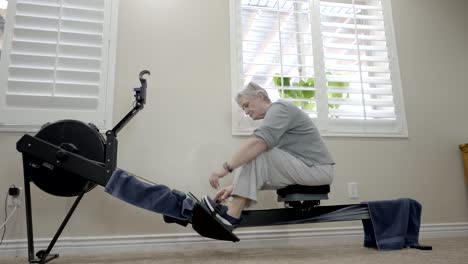 senior woman finishes exercise on a rowing machine