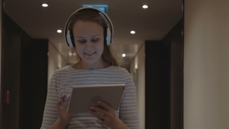 mujer con pad disfrutando de música en auriculares