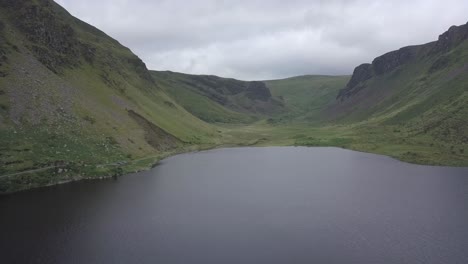 aerial establishing shot of mountain valley lake