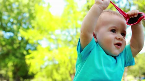 Cute-baby-boy-playing-with-red-sunglasses