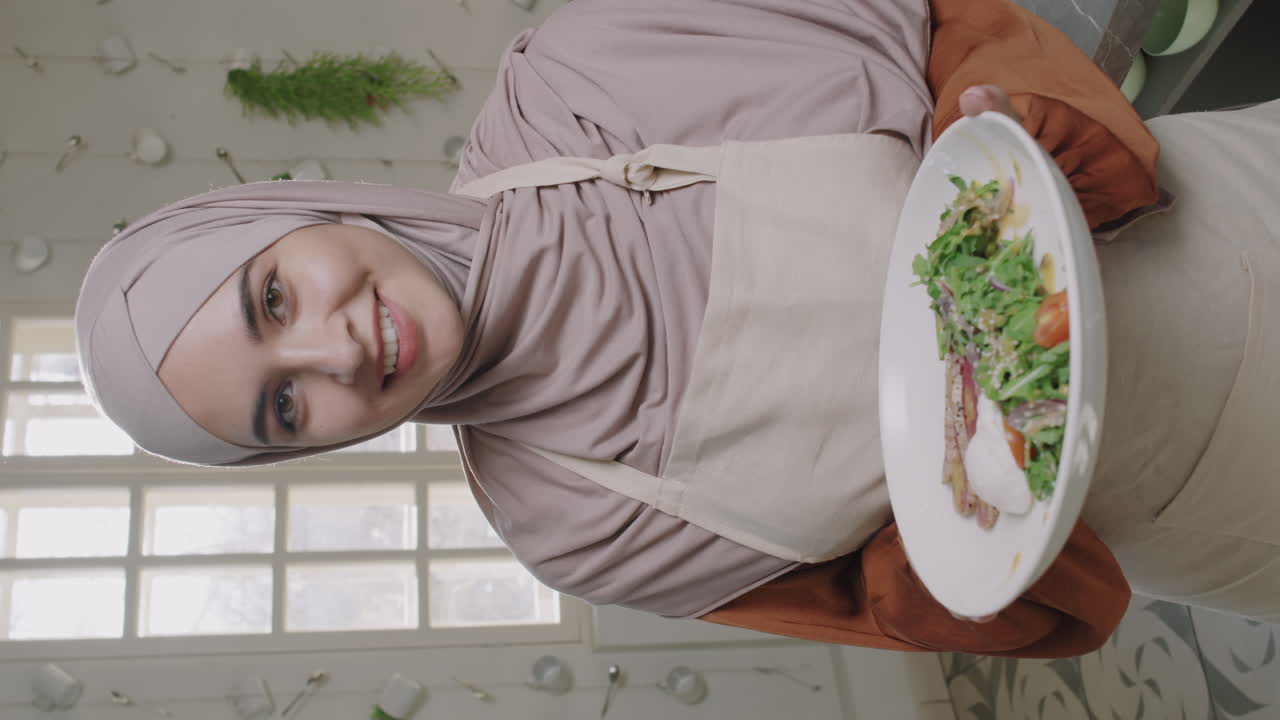 Woman in hijab presenting salad