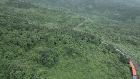 train powers around uphill curve on the hai van pass in vietnam while drone tracks