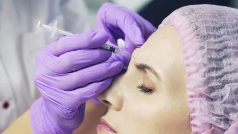 beautiful woman getting lifting injection in the middle of the forehead. facial cosmetology skin therapy