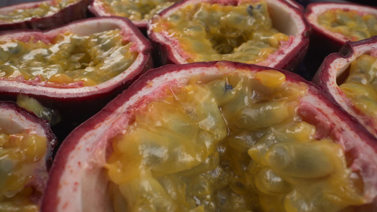 Hypnotiserende nærbillede af roterende passionsfrugter, saftige tropiske maracuja, eksotiske frugter, 4K makrooptagelse