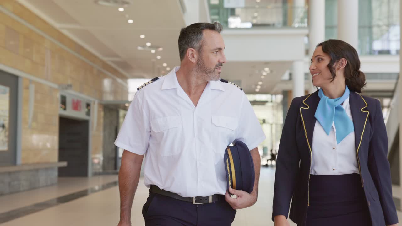 piloto feliz y azafata caminando en el aeropuerto