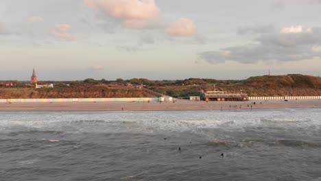 Surfers-in-front-of-the-touristic-town-Domburg-in-the-Netherlands-during-sunset