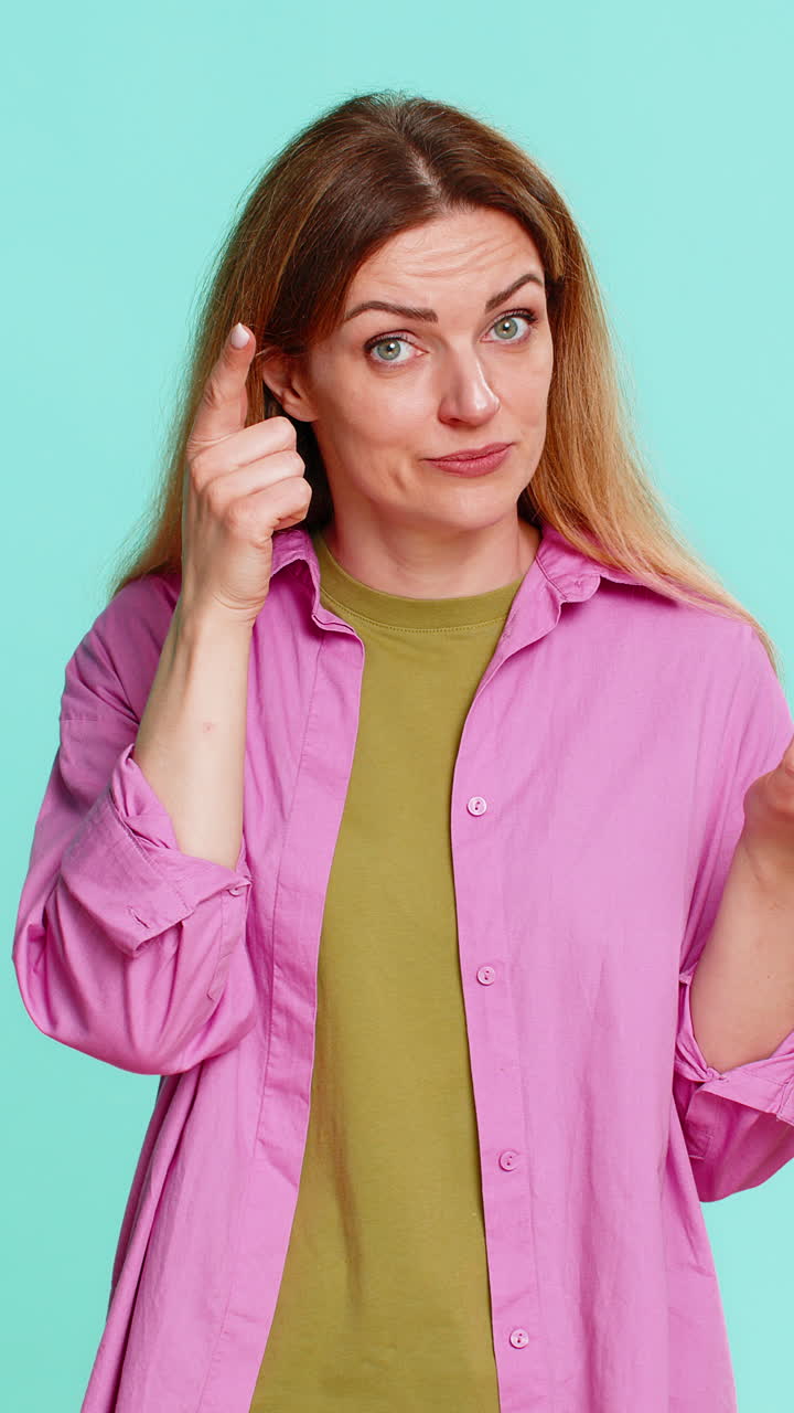 Woman spinning finger near temple showing crazy gesture disbelief or joking insult to silly behavior