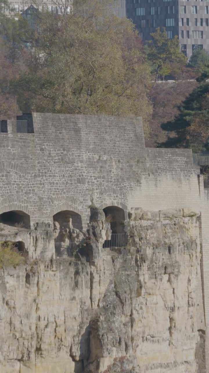 Old fort ruins on rocky hill in Luxembourg, surrounded by autumn trees