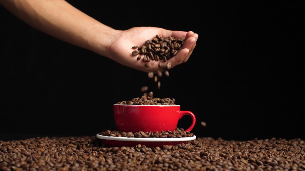 Hand Pouring Coffee Beans Into Red Cup, Slow Motion