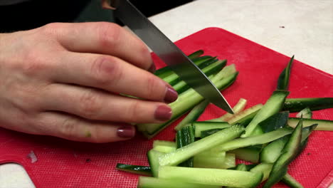 close up of woman's hands julienning cucumbers