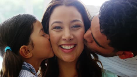 Father-and-daughter-kissing-mother-on-cheeks