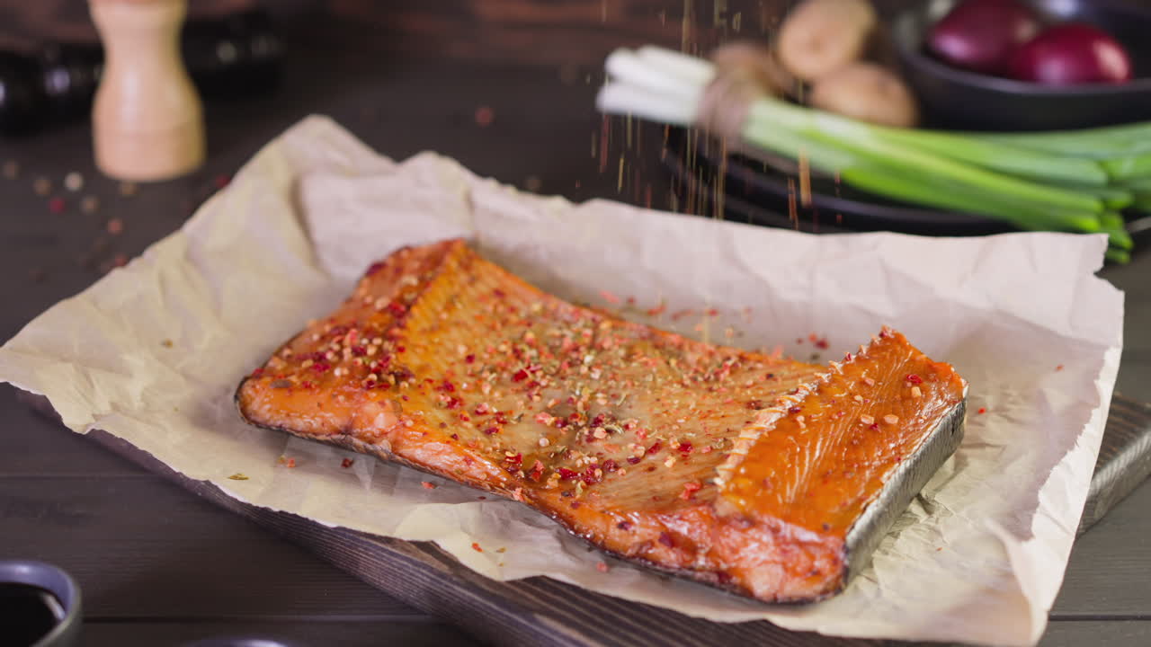 vertiendo especias en una costosa pieza de trucha ahumada en la mesa