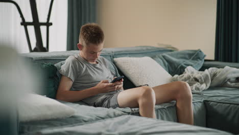 teenager using smartphone on couch