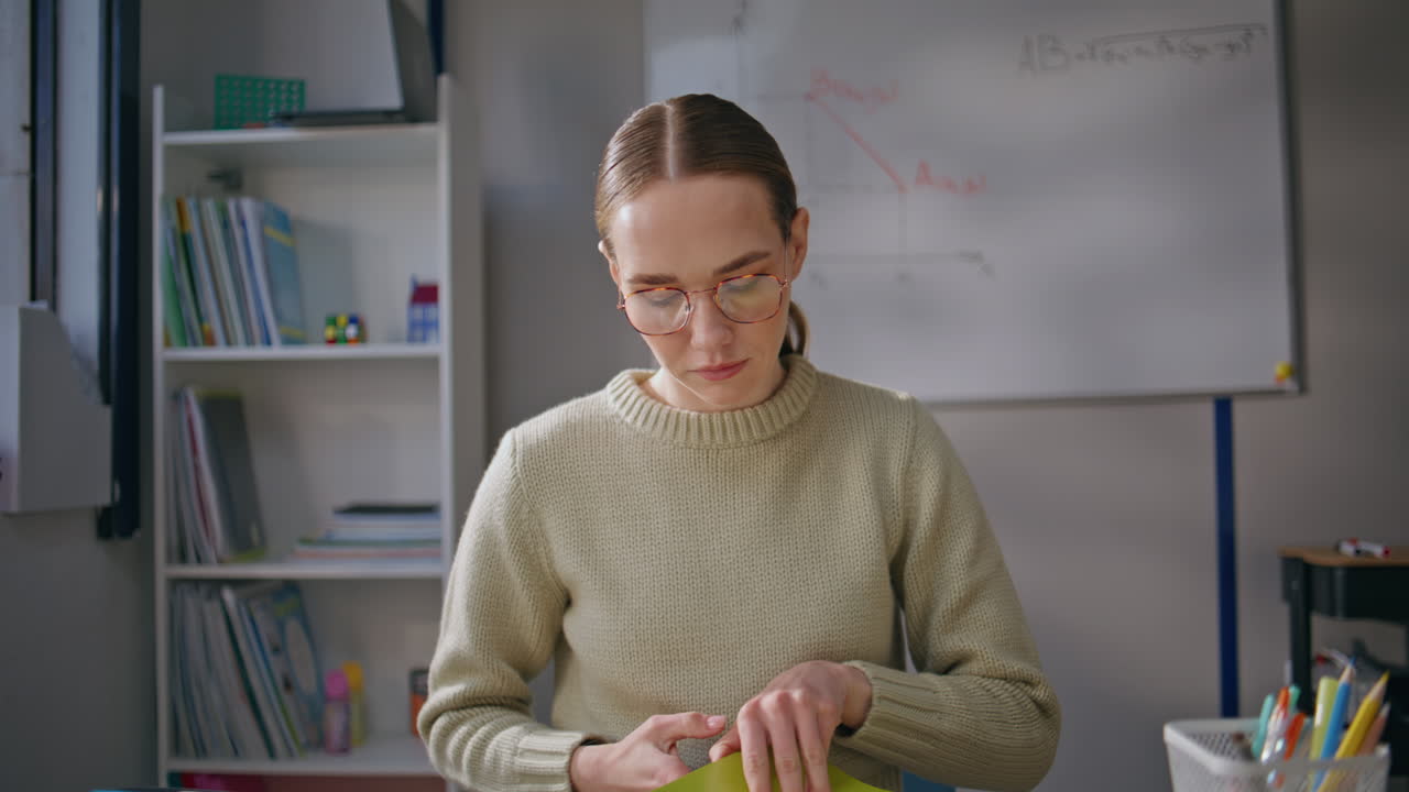 Woman teacher wearing glasses working at school closeup. Lady checking homework