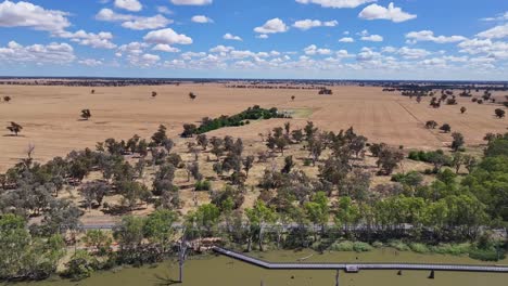 Looking-over-farmland-and-then-a-reveal-of-a-cycling-and-walking-track-over-Lake-Mulwala,-NSW,-Australia