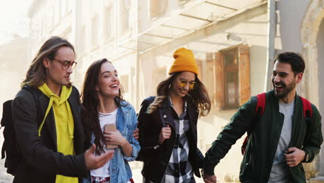 Junge-Kaukasische-Gruppe-Von-Freunden,-Die-Die-Straße-Hinuntergehen-Und-An-Einem-Schönen-Sonnigen-Tag-In-Der-Stadt-Reden