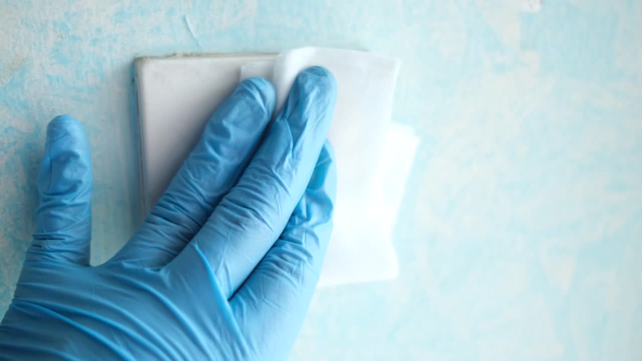 limpieza de un interruptor de luz con guantes