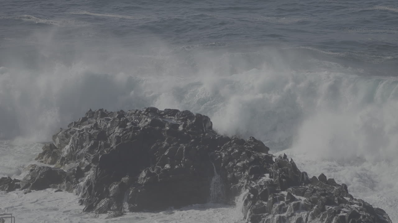 강력한 파도가 바위가 있는 해안에 부히고